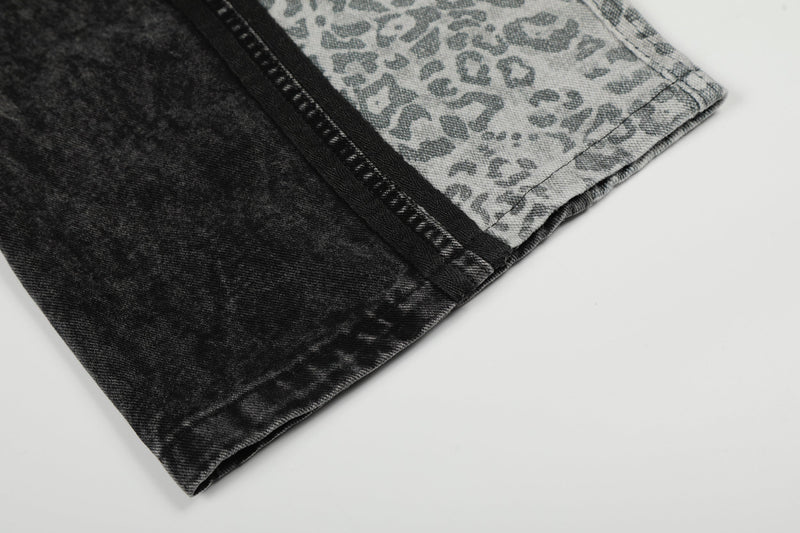 Close-up of hem on black denim wide-leg pants with leopard panel