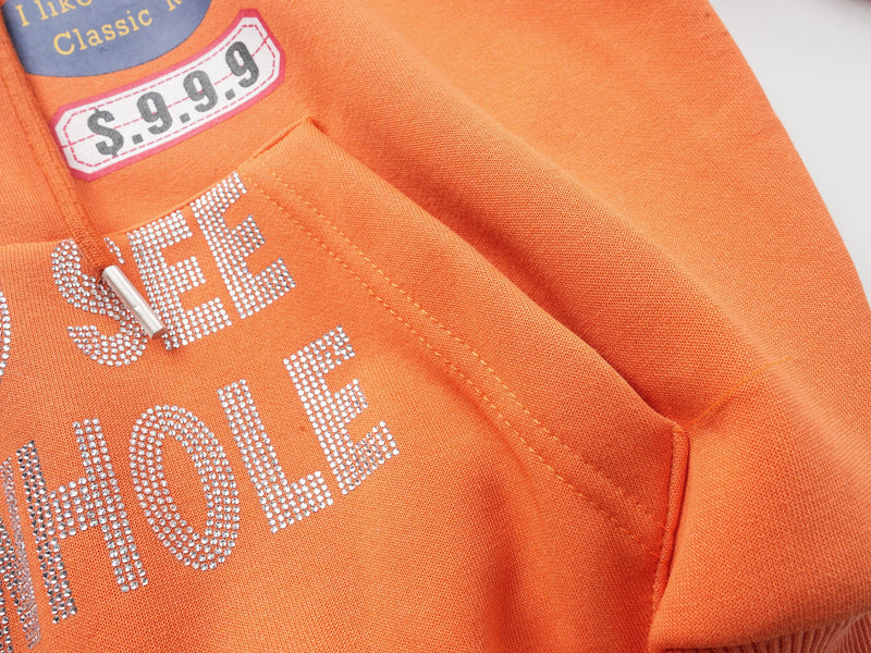 Close-up of rhinestone text and front pocket on the orange hoodie