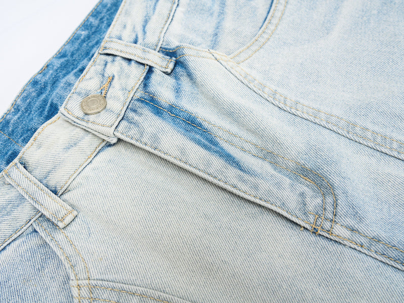 Close-up of front waist button and pocket seam on light wash denim jeans
