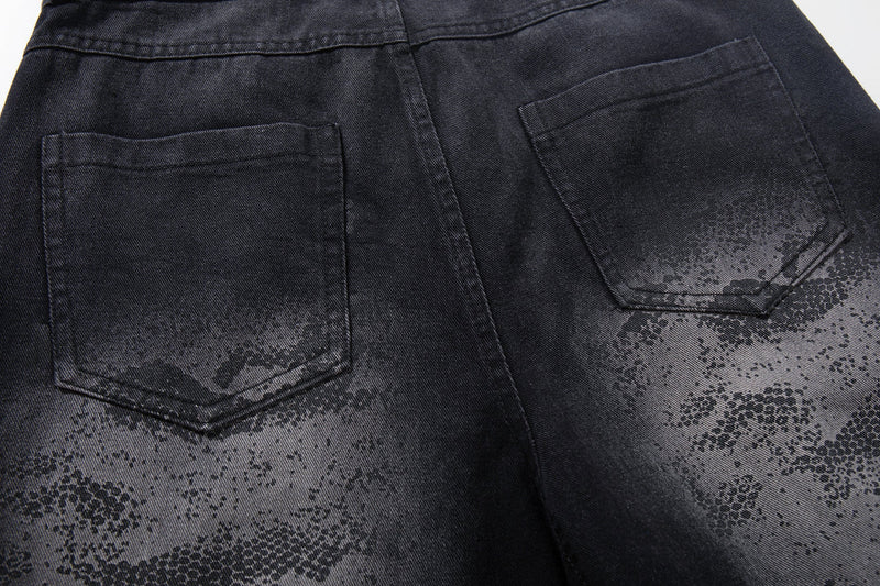 Back pocket close-up on dark jeans with faded camo graphic