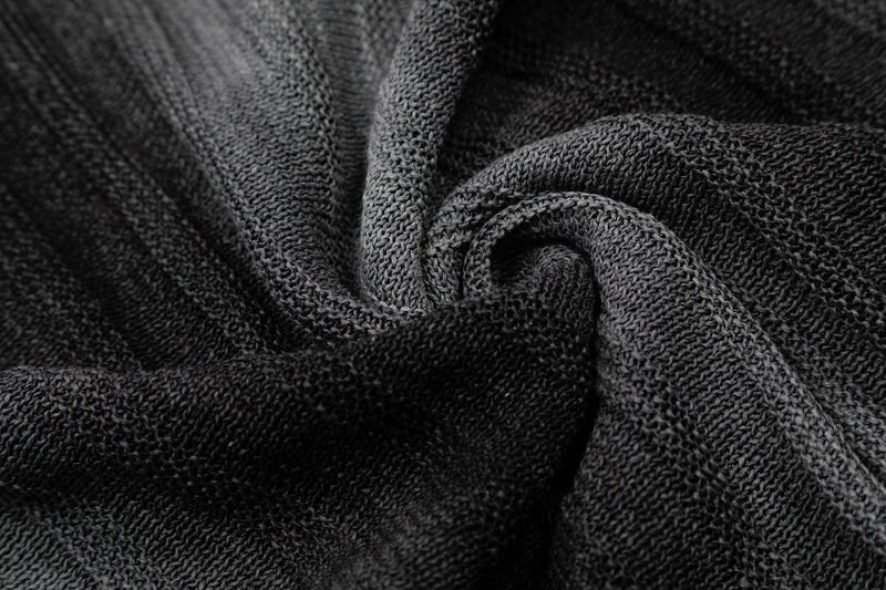 Close-up of black open-knit fabric with a textured gradient stripe pattern and soft relaxed drape