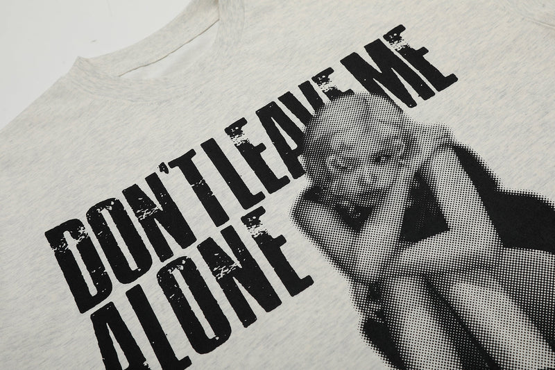 Oversized light gray graphic tee with bold Dont Leave Me Alone text and halftone face print