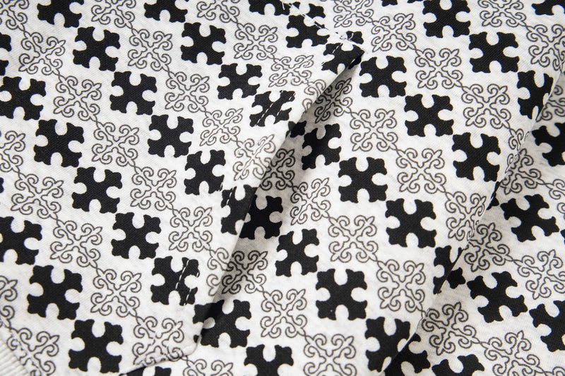 Close-up of black and white cross and scroll pattern fabric
