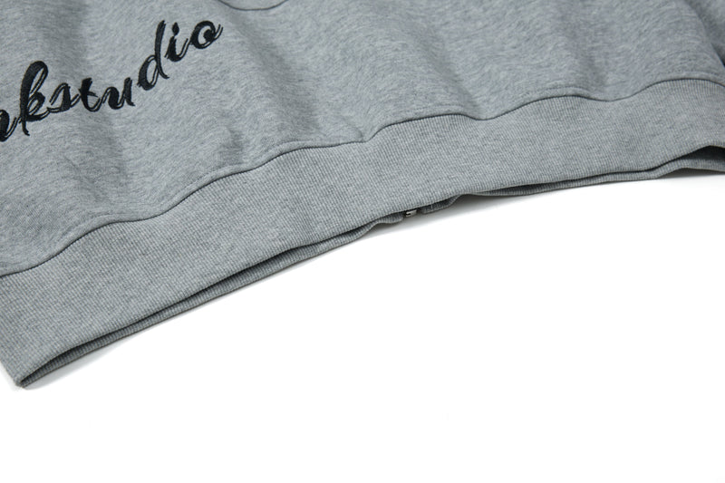 Close-up of gray hoodie hem with partial script graphic