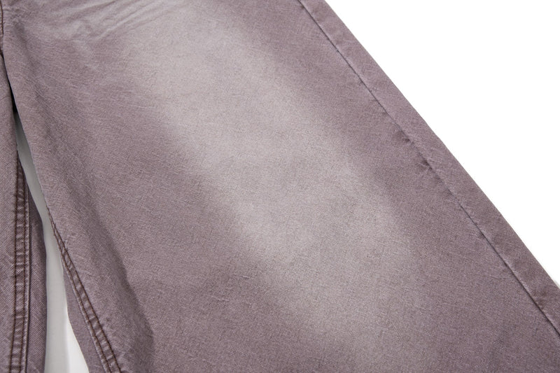 Close-up of brown denim leg with faded wash and side seam