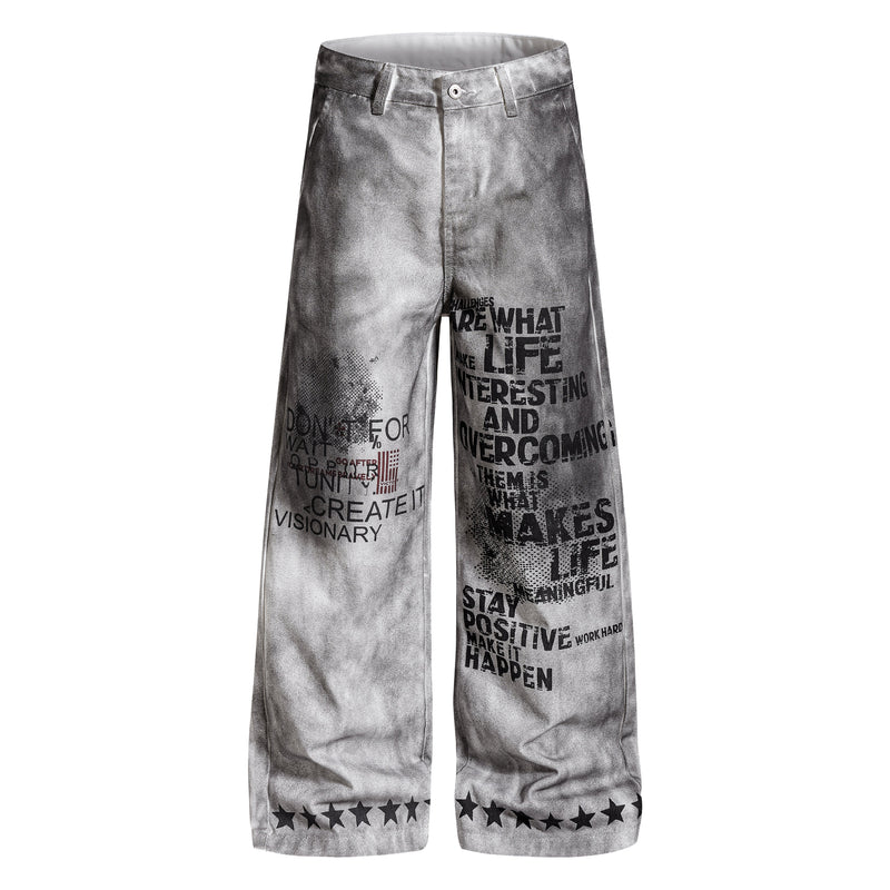 Front view of gray washed wide-leg pants with black graphic text and star hem print