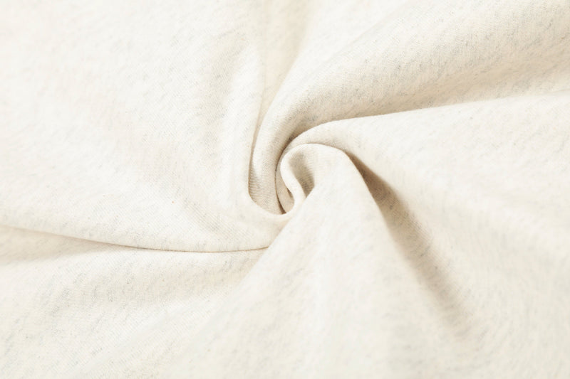 Close-up of cream hoodie fabric fold showing smooth cotton fleece texture