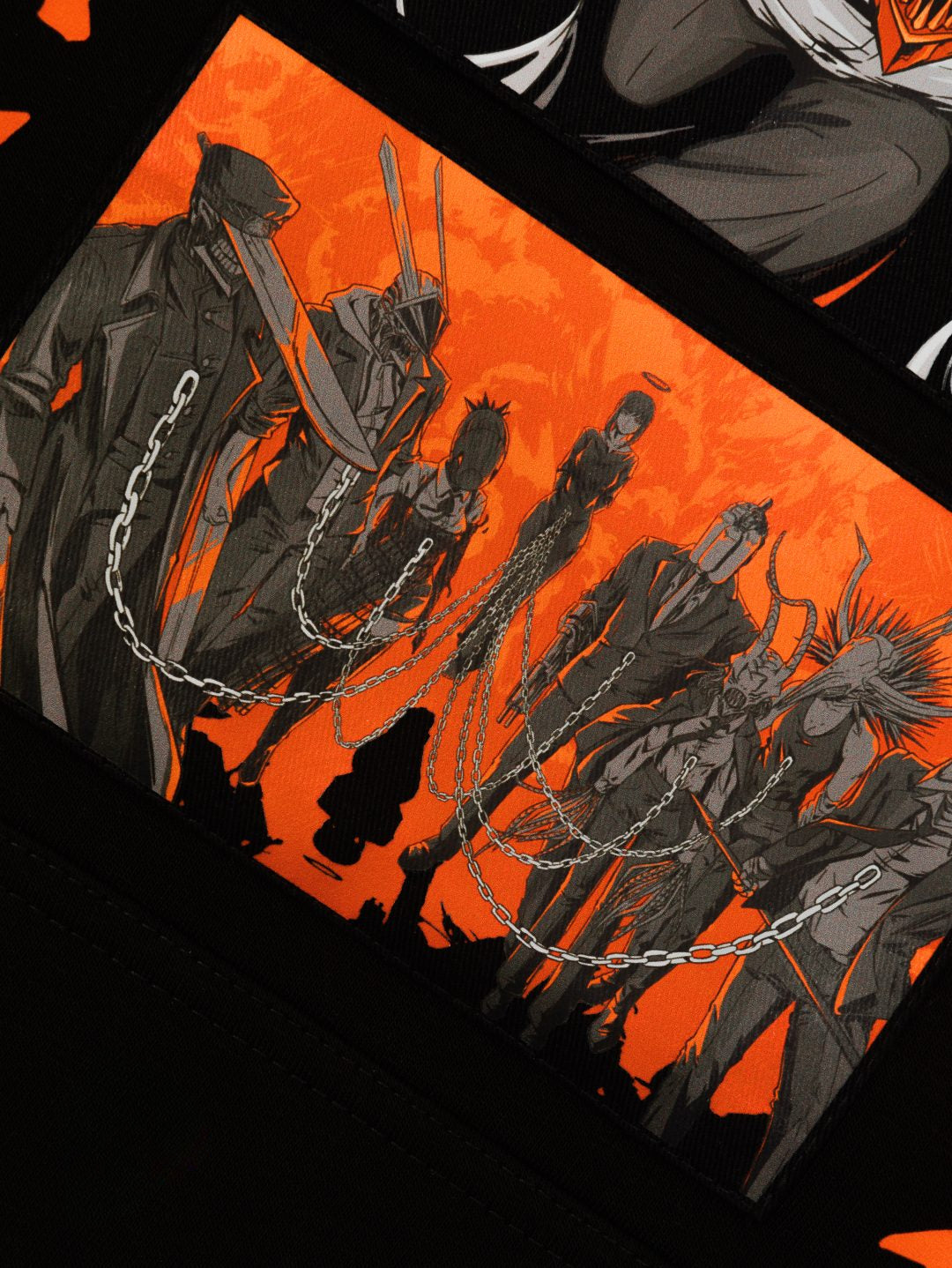 An illustration shows stylized characters in black outfits with chains on an orange background, channeling anime fashion with horns and helmets. This dramatic scene evokes the bold style of the Chainsaw Man Hoodie, made of high-quality 360 GSM cotton.