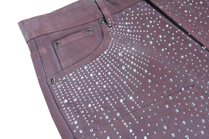 Close-up of front pocket and rhinestone detailing on dark brown denim shorts