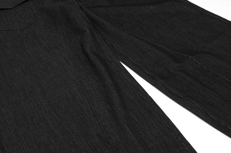 Close-up of black wide-leg denim pants showing full leg drape and seam lines