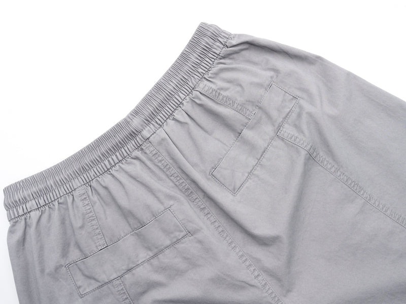 Close-up of gray shorts back patch pockets and elastic waistband
