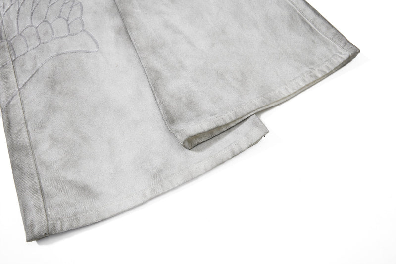 Close-up of light gray flare leg hem with washed denim texture