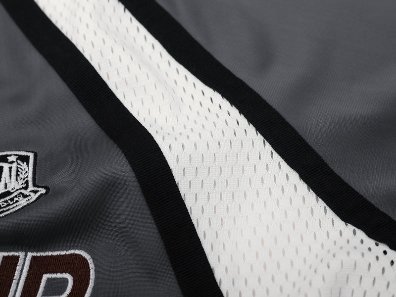 Close-up of white mesh side panel with black trim and embroidered crest on gray top