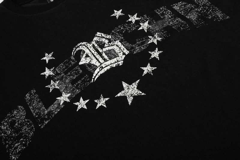 Close-up of front graphic on black tee with star circle and worn lettering