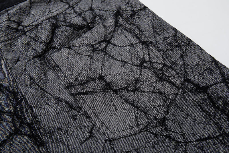 Close-up of gray denim fabric with cracked print and stitched seam detail