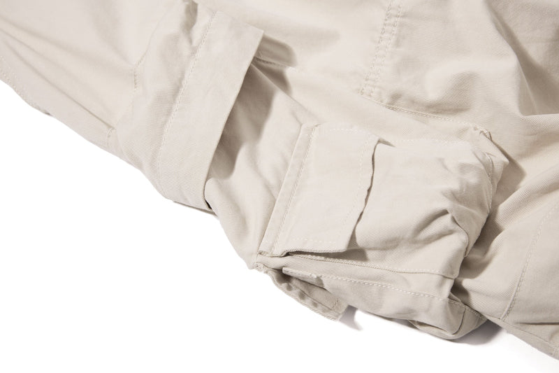 Close-up of beige cargo pocket flap and side seam detail