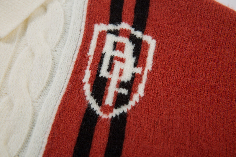 Close-up of red sleeve patch with embroidered varsity crest on cable-knit jacket