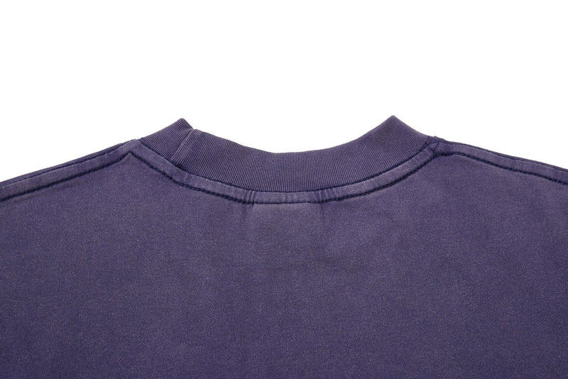 Close-up of a washed purple vintage streetwear tee with a ribbed crew neck and visible seam details