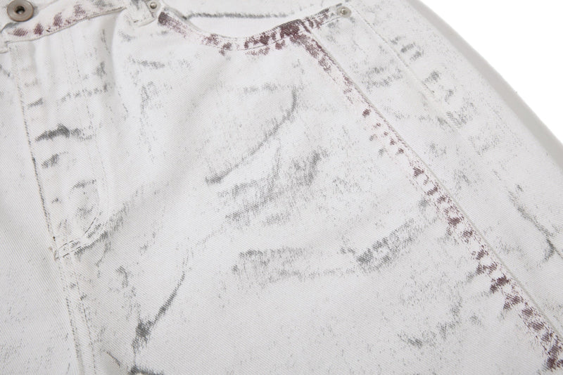 Close-up of front hip area on white washed denim pants with marbled panel stitching