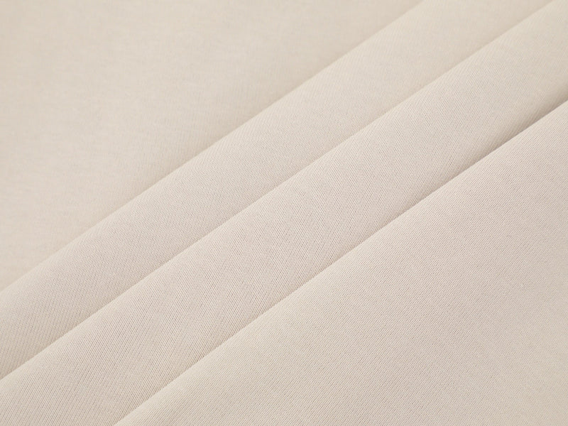 Close-up of cream tee fabric with soft draped folds