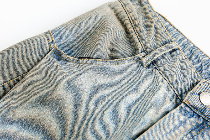 Close-up of rear yoke and back pocket on faded light blue barrel leg jeans