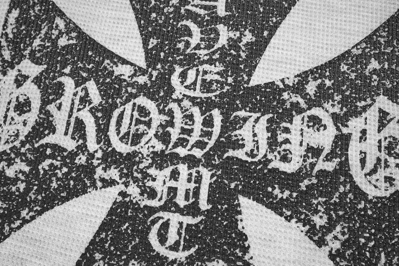 Close-up of distressed cross graphic on white waffle-knit sweatshirt
