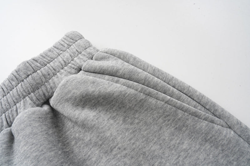 Close-up of gray sweat shorts hem and side seam on a white background