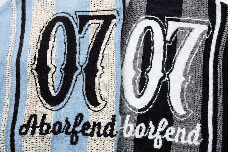 Close-up of front and back number graphics on light blue and black striped knit sweaters