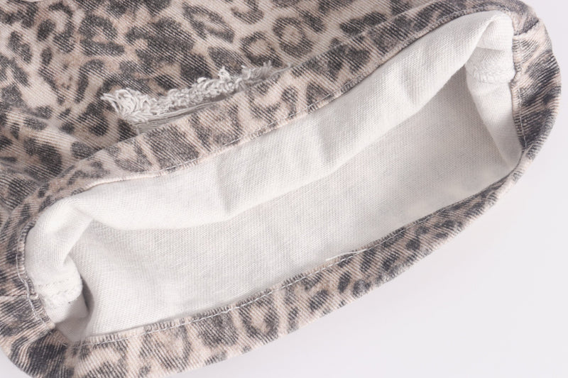 Close-up of hem showing white inner lining on leopard print jeans