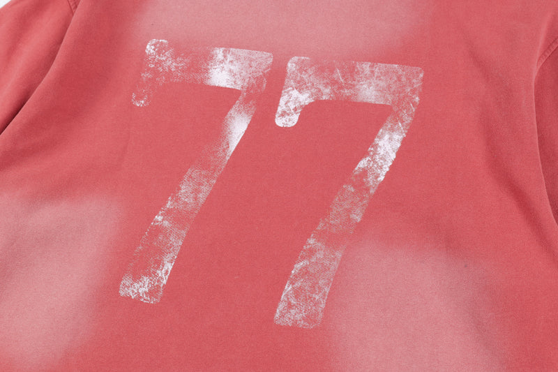 Close-up of faded 77 print on the red hoodie front