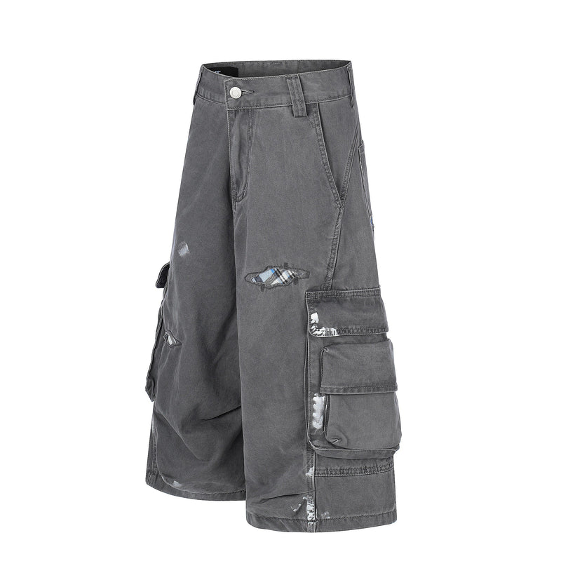 Gray cargo shorts angled front view showing utility pockets and worn patches