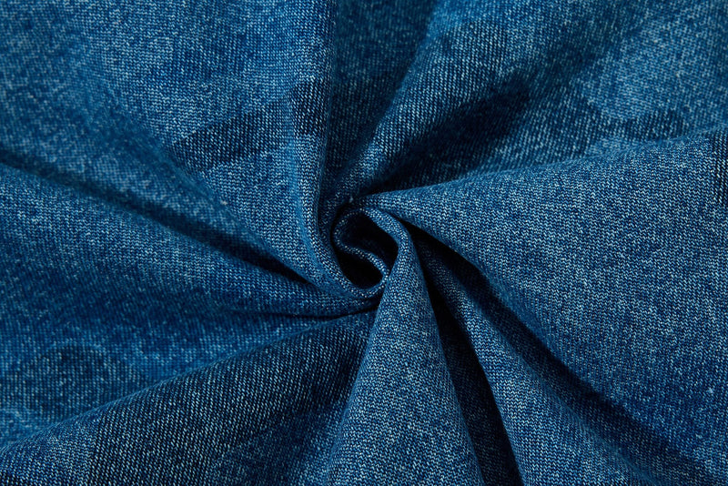 Close-up of gathered denim fabric showing washed blue camo texture