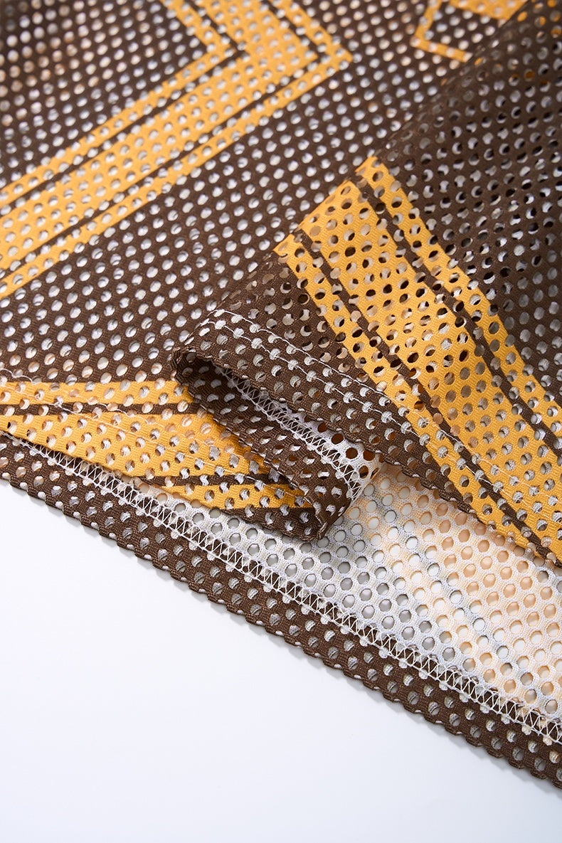 Close-up of brown and gold mesh jersey fabric with retro star and 77 striped detailing, showing hem stitching