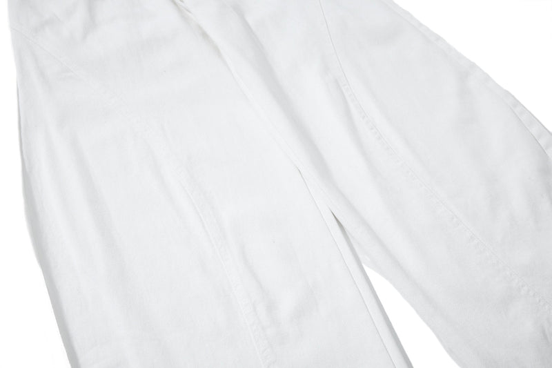Close-up of white pant leg showing smooth fabric and wide cut