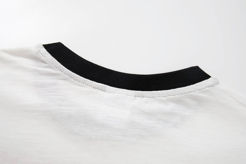 White vintage graphic tee with black ribbed crew neck and stitched collar detail close-up