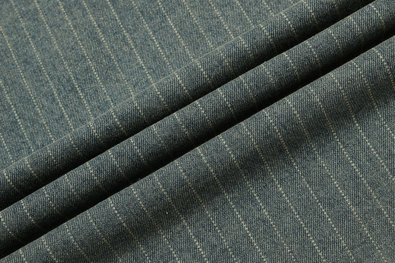 Close-up of vintage blue pinstripe denim fabric with textured folds and subtle faded pattern