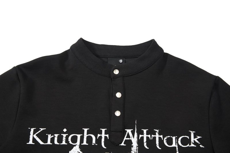 Black polo tee with ribbed collar, silver snap buttons, and distressed Knight Attack graphic print on the chest