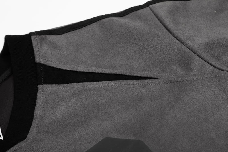 Close-up of a gray colorblock varsity mesh jersey tee with black trim and stitched panel seams