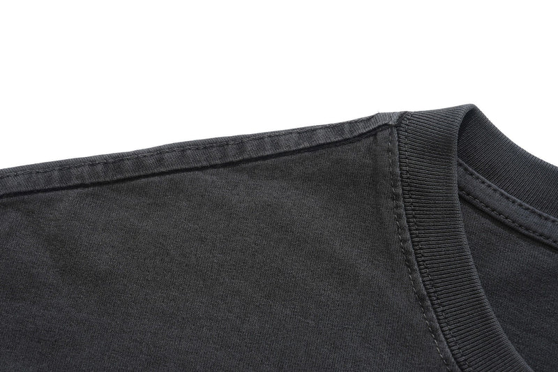 Close-up of a black vintage washed graphic T-shirt with ribbed crew neckline and visible stitching
