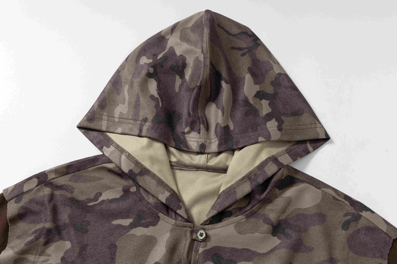 Camouflage hooded short-sleeve tee with oversized fit and button front, shown in a close-up of the hood and chest detail