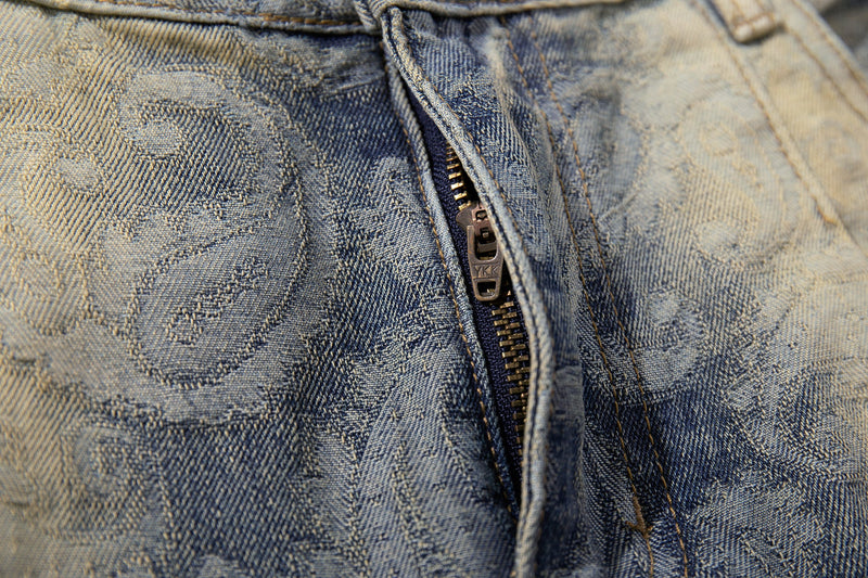 Close-up of denim zipper fly and paisley pattern