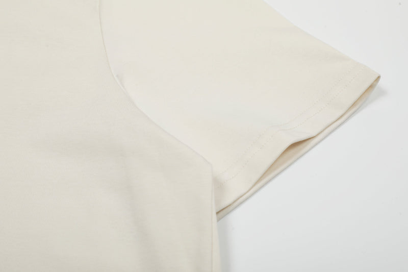 Cream graphic t-shirt sleeve with clean hem and soft coastal-inspired fabric texture