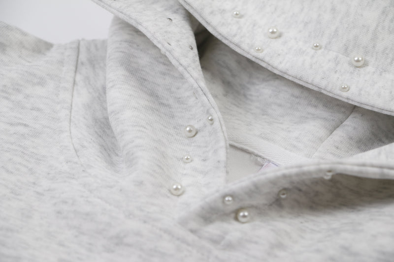 Close-up of gray hoodie hood lining with pearl studs on the inside seam
