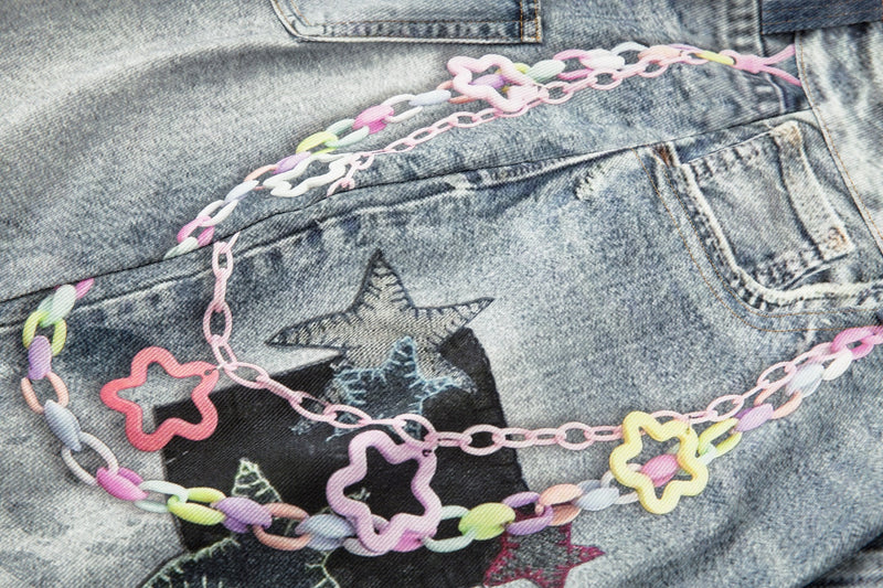 Close-up of back pocket area with pastel chain trim and star patch on denim shorts