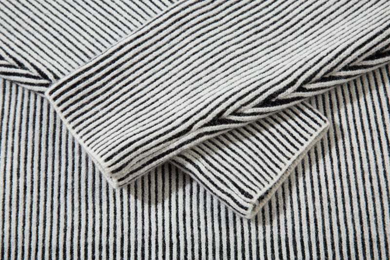 Close-up of white striped ribbed knit sleeves layered together
