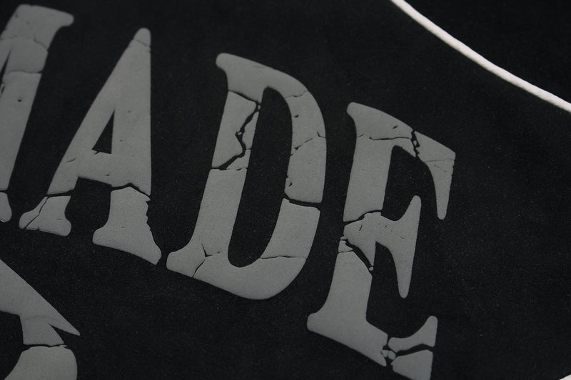 Close-up of black hoodie print showing cracked gray lettering