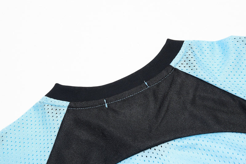 Close-up of a black and light blue mesh jersey collar with stitched seams and perforated sports fabric detailing