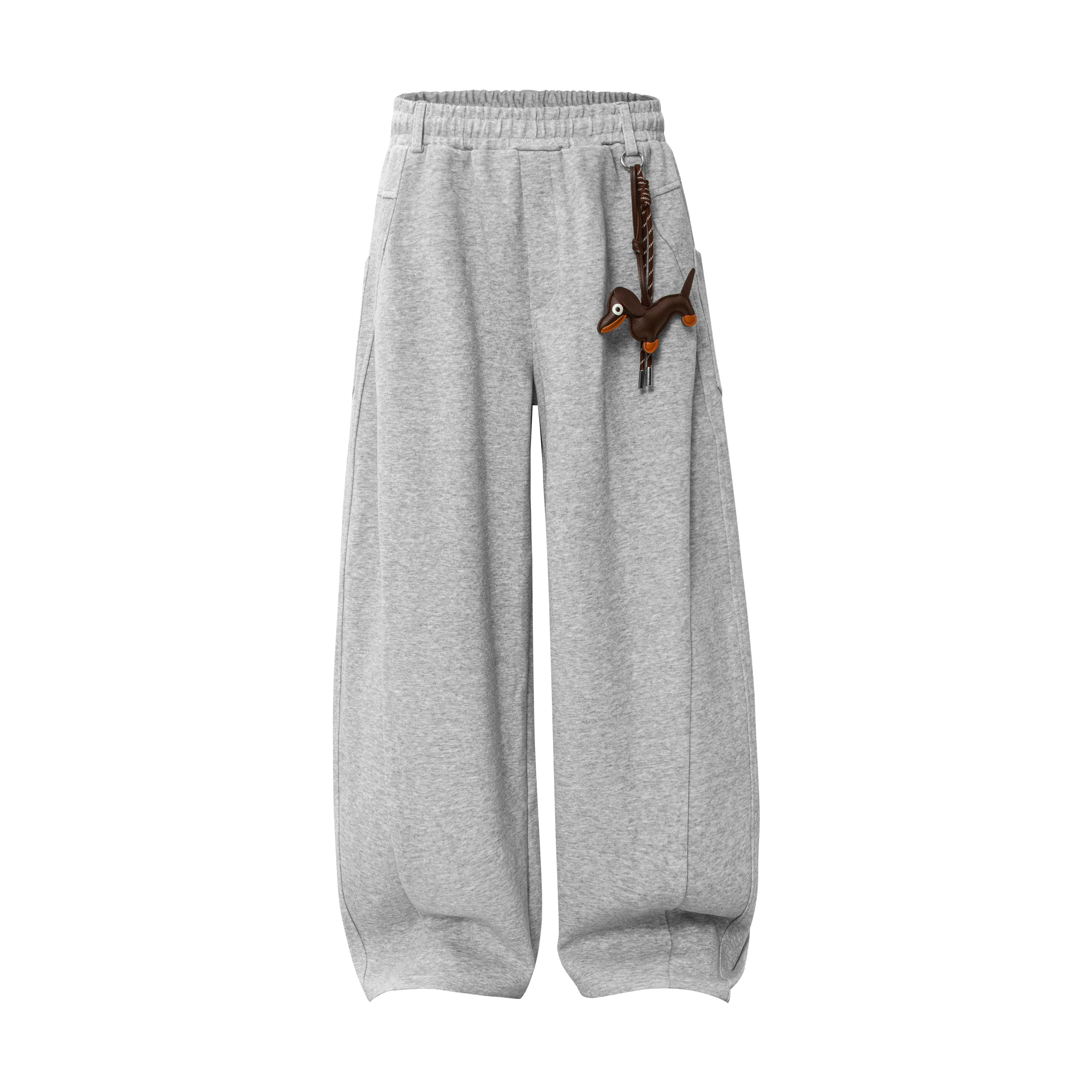 Grey wide-leg balloon sweatpants with detachable dachshund plush charm clipped to the elastic waistband, front view