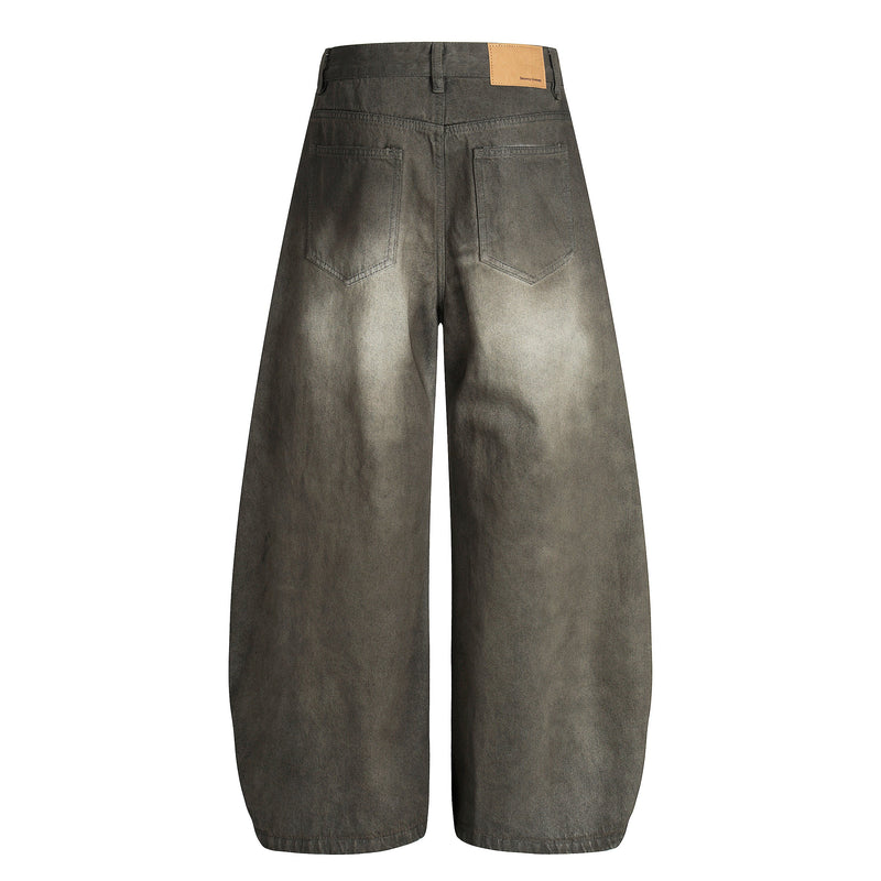 Back view of faded black wide-leg denim pants with patch pockets and tan logo waistband tab