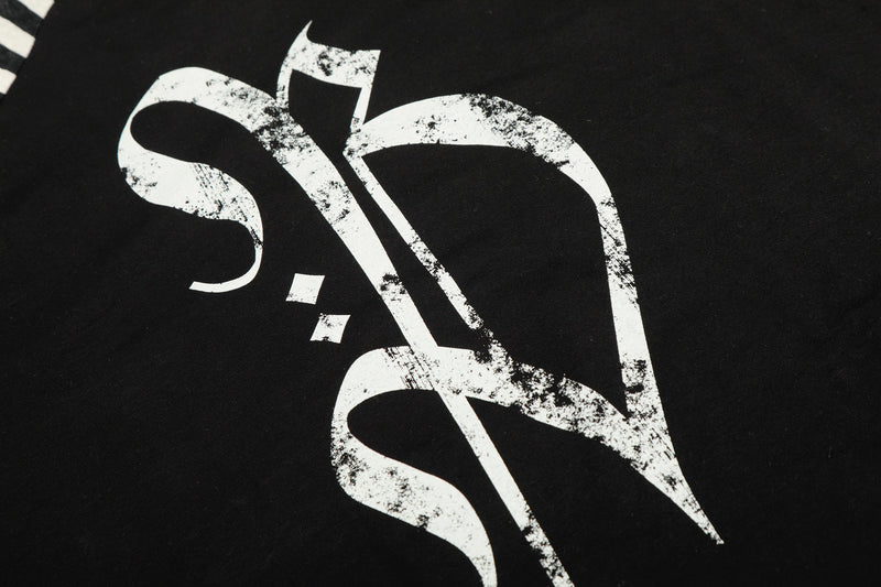 Close-up of gothic cross graphic and lettering printed on black tee
